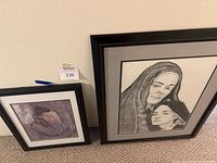 Two framed lithographs leaning against wall with lot number sticker