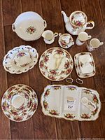 Overview of all dinnerware, tea service, serveware, mugs, napkin rings on wooden floor