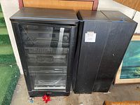 Front view of wood-grain cabinet housing stereo components and adjacent floor speaker pair