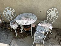 Overview of set with round table, two chairs and plant stand