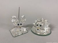 Photo of two Swarovski crystal figurines, mouse on square base and porcupine on round base