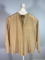Front view of beige long sleeve silk blouse with light check pattern on mannequin.
