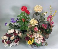 Full view of all seven potted faux flower arrangements together by wall