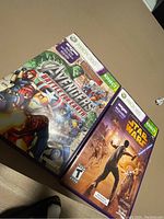 Two Xbox 360 Kinect game cases on a floor: Avengers Battle for Earth and Star Wars The Clone Wars shown with cover art and Kinect branding visible.
