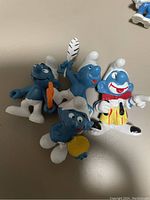 Photo of three Smurf figurines, two standard Smurfs and one Clown Smurf in colorful outfit