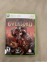 Front cover of Overlord Xbox 360 game case showing the game's title, ESRB rating T for Teen, and artwork of armored character with sword and goblins.