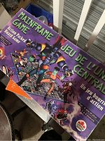 Photo of Manframe Board Game box showing colorful illustrated cover with English and French title and branding.