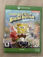 Front cover of SpongeBob SquarePants Battle for Bikini Bottom Rehydrated game case for Xbox One, showing colorful character artwork and branding.