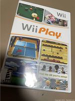 Front cover of Wii Play video game for Nintendo Wii, sealed in original shrink wrap, featuring images of game mini-modes and the Wii Play logo.