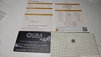 GRA certification document and warranty card with moissanite gemstone on a white surface.