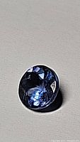 Front view of deep blue purple diamond cut tanzanite gemstone showing clarity and color.