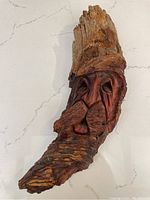 Front view of the hand carved wooden man's face sculpture highlighting the carved facial details and textured beard.