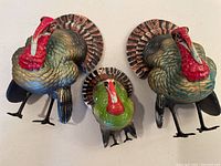 Three turkey figurines showing painted details and standing posture