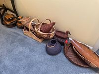Overall view of assorted baskets grouped on floor against wall