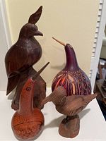 Group photo showing all four carved birds together on a table.
