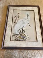 Full view of framed egret print showing two egrets on natural posts with ceramic or wooden frame and light textured mat.