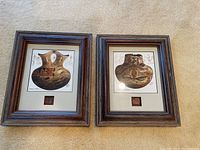 Pair of framed Michael McCullough pottery prints with pottery shards embedded in the mats, shown side by side on carpeted floor.