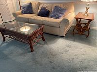 Coffee table and side table arranged near sofa on carpeted floor