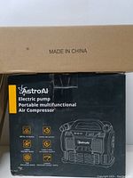 Black box of AstroAI Electric Pump Portable Multifunctional Air Compressor featuring product features and diagram.