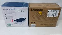 Lot contains two boxed air beds side by side, one in blue and white box and one in brown box with brand GMORNXEN.