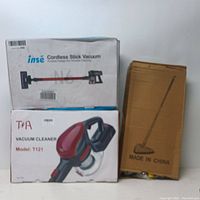 Photo showing three boxed items: inse Cordless Stick Vacuum Model N6, handheld vacuum Model T121 by TNA, and boxed floor broom.