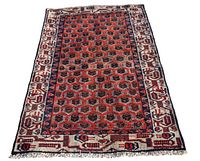 Full view of the Hamadan wool rug showing the entire rectangular piece with the red octagonal repeating pattern and white floral border.