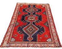Full view of Persian Saveh rug showing geometric large pattern and red background with navy blue elements.