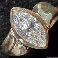Close-up photo of the sterling silver ring showing marquise cut clear stone on polished band with visible wear.