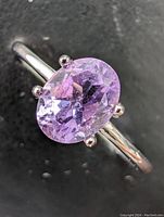 Close-up of the ring showing oval cut light purple amethyst gemstone set in sterling silver with polished prong setting.