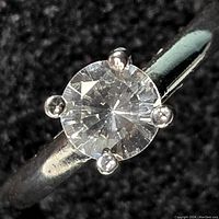 Close-up front view of the sterling silver ring showing the clear round stone and the prong setting.