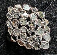 Close-up view of the front lattice design of flat diamonds in silver setting showing the pear and oval shaped bezel-set diamonds.