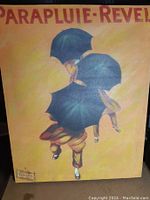 Front of French art print titled 'Parapluie-Revel' with two figures holding black umbrellas and yellow background.