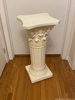 Full view of the cream coloured ceramic pedestal showing its column-like shaft and square top.
