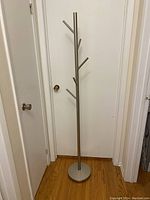 Full view of coat rack showing overall height and design against a white door background.