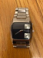 Front view of the Nixon Banks watch showing black square dial with two subdials and stainless steel bracelet.