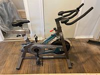 Side view of Free Spirit stationary bike showing frame, saddle, pedals, and crank area with 'Sprint Winner' label.