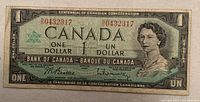 Front side of the 1967 Canadian one dollar bill showing the serial number 0432317, Queen Elizabeth II portrait, and bilingual text.