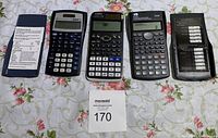 Front view of five scientific calculators laid out side by side showing buttons and displays