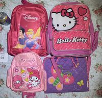 Photo showing all four bags together: Disney Princess backpack, Hello Kitty backpack, My Melody backpack, and purple butterfly tote bag.
