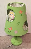 Photo of unlit green table lamp with owl and bird cut-out shade
