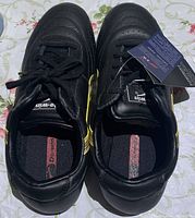 Top view of brand new black Do-Win martial arts shoes with laces and tagged labels, showing insole and shoe opening.