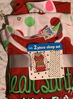 Photo showing New With Tags Justice 2 piece sleep set size 12 with red long-sleeve top and polka dot pants