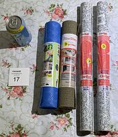 Top view of four rolled liners and coverings with soda can for scale