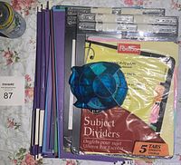 Multiple files, subject dividers, and pen holder arranged on floral surface