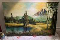 Full view of the original signed landscape oil painting showing trees, water, mountains and sky.