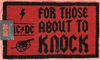 Full view of the red and black front door mat with AC/DC logo and phrase 'FOR THOSE ABOUT TO KNOCK'.