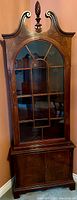 Full view of antique Duncan Phyfe mahogany corner cabinet with glass door and decorative crown