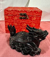Black resin Fengshui Dragon Tortoise statue with dragon head and tortoise body, shown with the original red ornamental box in the background.