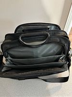 Top view showing multiple compartments and divider pockets inside the black briefcase