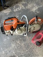 Side view of Stihl TS 400 saw with attached segmented diamond blade and red fuel container on concrete floor